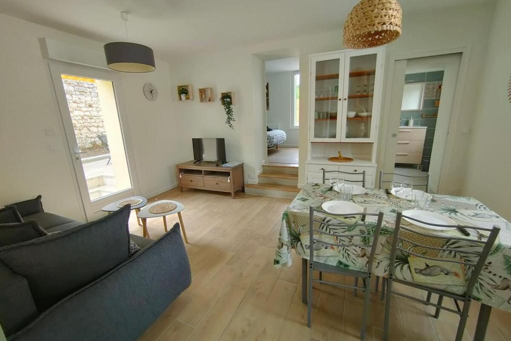 un salon avec une table, des chaises et un canapé dans l'établissement Les pivoines au calme 15min du zoo, à Meusnes