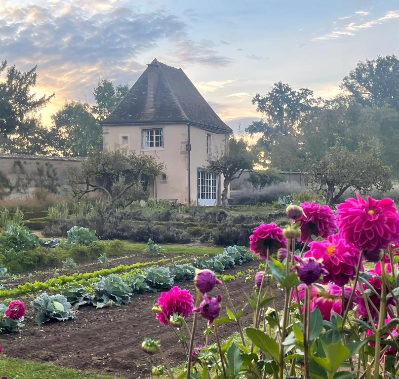 un jardin fleuri devant une maison dans l'établissement Romantic cottage in garden of Château de La Motte-Feuilly, à La Motte-Feuilly