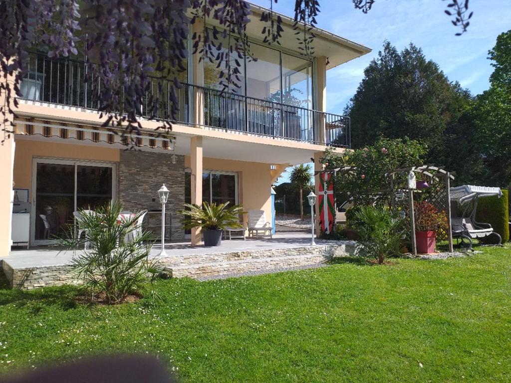 a house with a balcony and a yard at Rez-de-jardin 50 m² entre Biarritz et Capbreton in Ondres