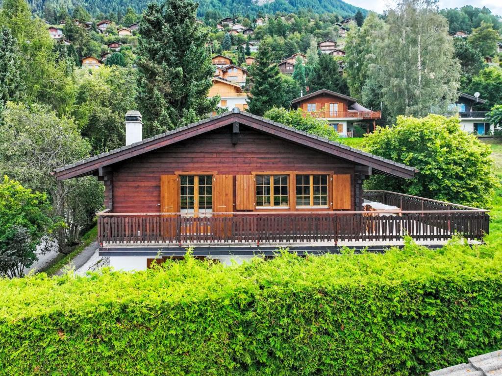 a wooden house with a balcony on a mountain at Chalet La Couronne by Interhome in Nendaz
