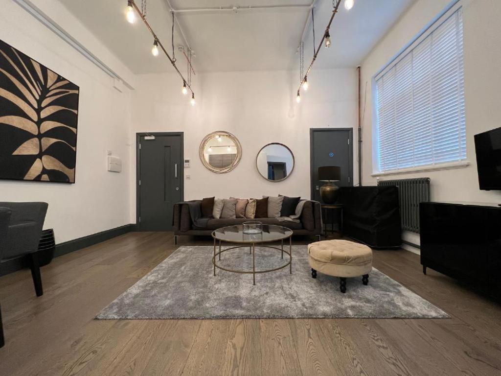 un soggiorno con un divano e un tavolo di Cool warehouse conversion apt in Chiswick London a Londra