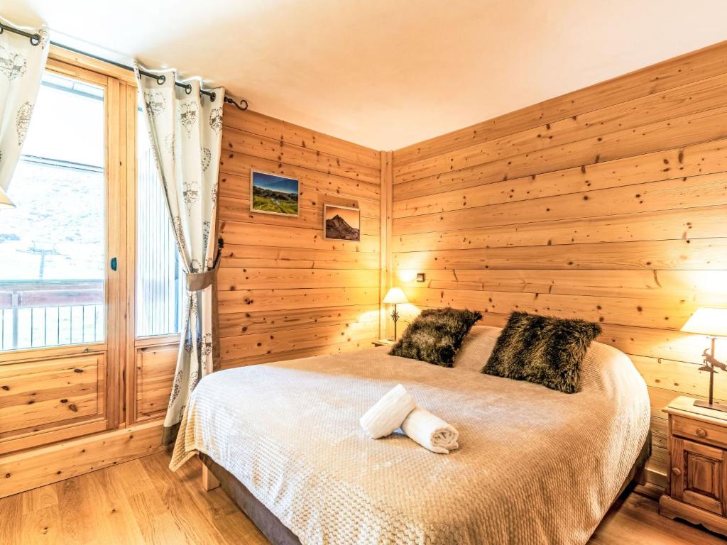 une chambre avec un lit avec des murs en bois et une fenêtre dans l'établissement Apartment Les Tommeuses - Val Claret-37 by Interhome, à Tignes