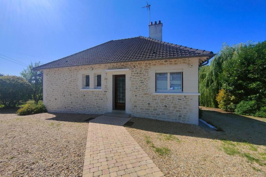 une petite maison en briques sur une allée de gravier dans l'établissement Le paradis des pécheurs, à Châtillon-sur-Cher