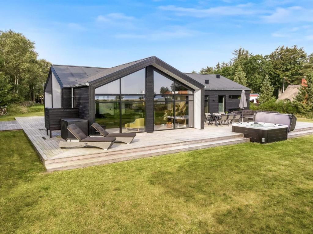 a contemporary house with a large deck and glass walls at Holiday Home Jahn - 250m to the inlet by Interhome in Højslev
