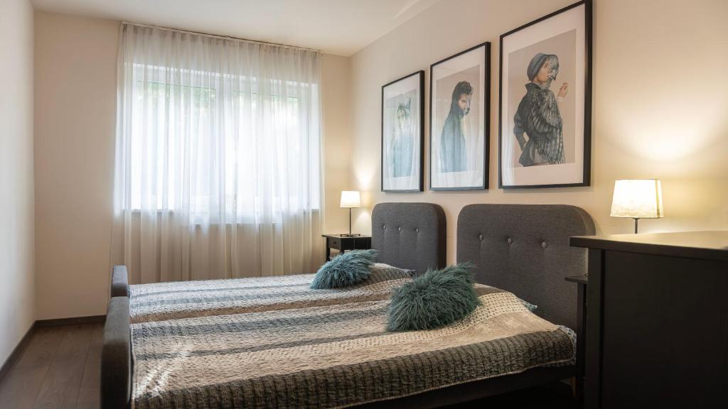 sypialnia z łóżkiem z 2 krzesłami i oknem w obiekcie Thermal Forest Apartment w mieście Kiskunhalas