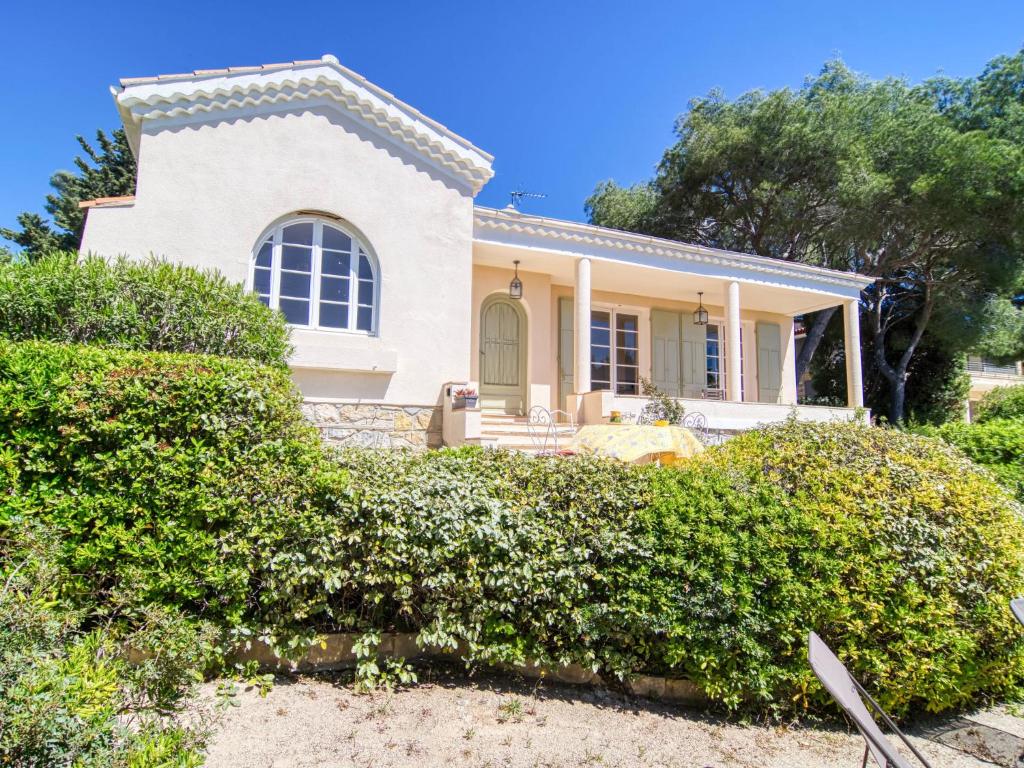 une maison blanche avec des buissons devant elle dans l'établissement Holiday Home Le Farigoulo by Interhome, à Sanary-sur-Mer