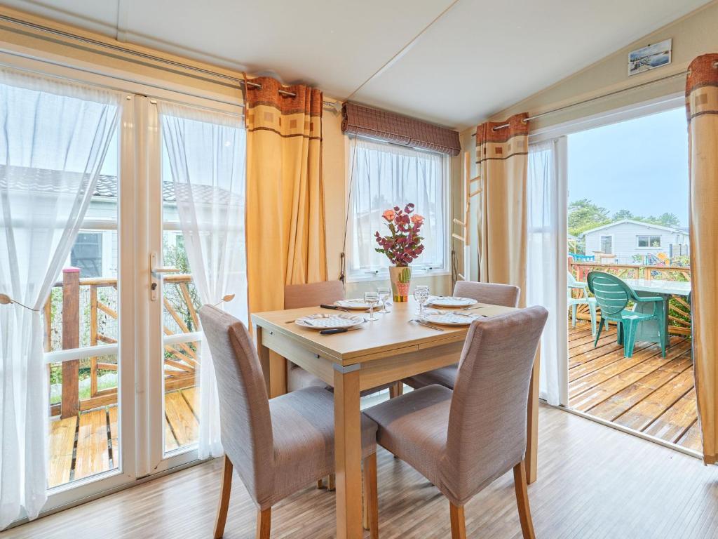 une salle à manger avec une table et des chaises et un balcon dans l'établissement Holiday Home Rêves & Sérénité by Interhome, à Saint-Georges-de-la-Rivière