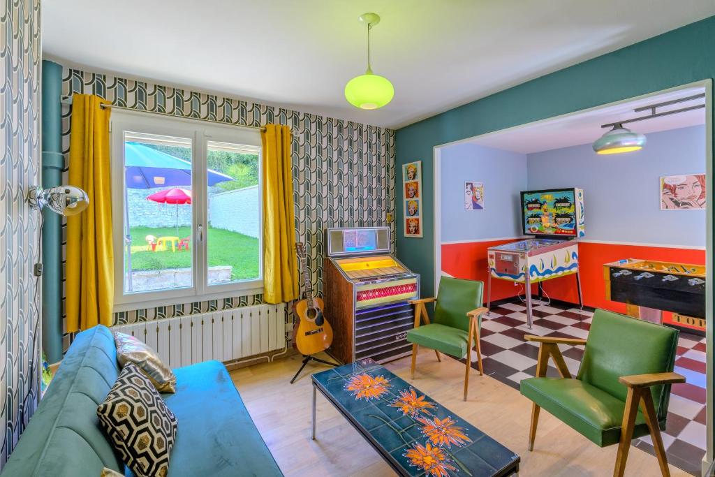 a living room with a blue couch and a window at Sixties Forever - une immersion années 60 in Aubenton