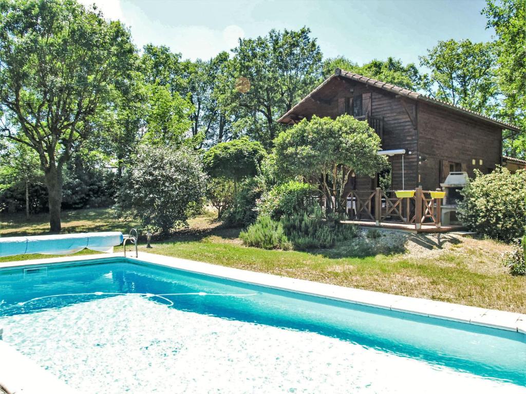 une maison avec une piscine devant une maison dans l'établissement Holiday Home L'Eglantier by Interhome, à Loupiac
