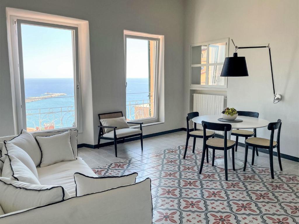 a living room with a couch and a table and chairs at Apartment Mareviglia - Meereswunder by Interhome in Imperia