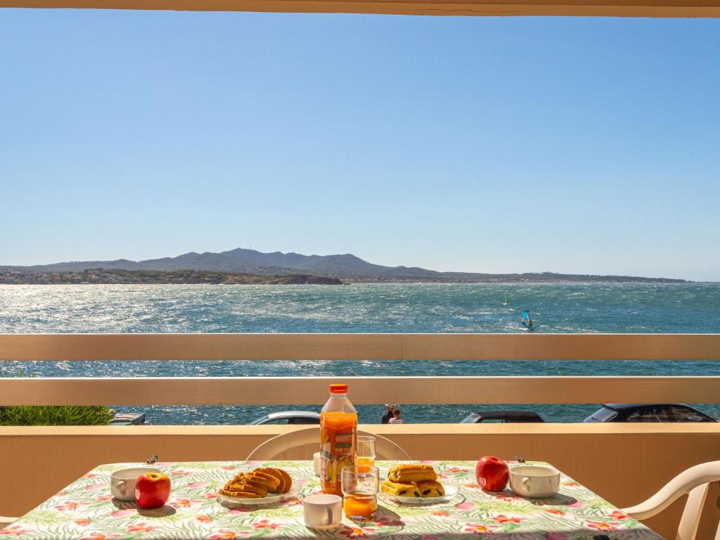 - une table avec de la nourriture et une vue sur l'océan dans l'établissement Apartment Résidence Les Flots by Interhome, à Sanary-sur-Mer