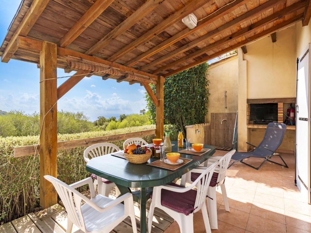 un patio avec une table et des chaises et une cuisine dans l'établissement Holiday Home Casa Murticcio 1 by Interhome, à Bonifacio