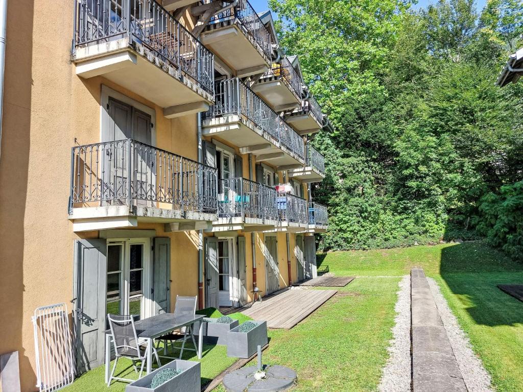 - un bâtiment avec des balcons, des tables et des chaises sur la pelouse dans l'établissement Apartment Conseil-9 by Interhome, à Saint-Gervais-les-Bains