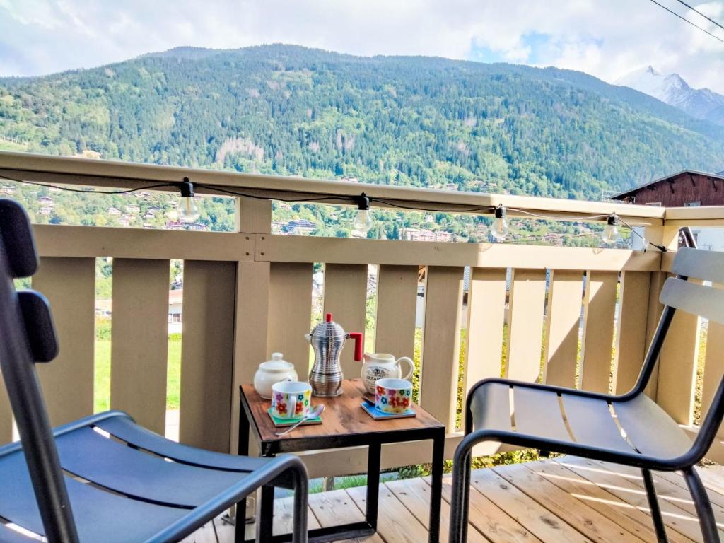 d'une table et de deux chaises sur un balcon avec vue sur les montagnes. dans l'établissement Apartment Chalet du Rosay by Interhome, à Saint-Gervais-les-Bains