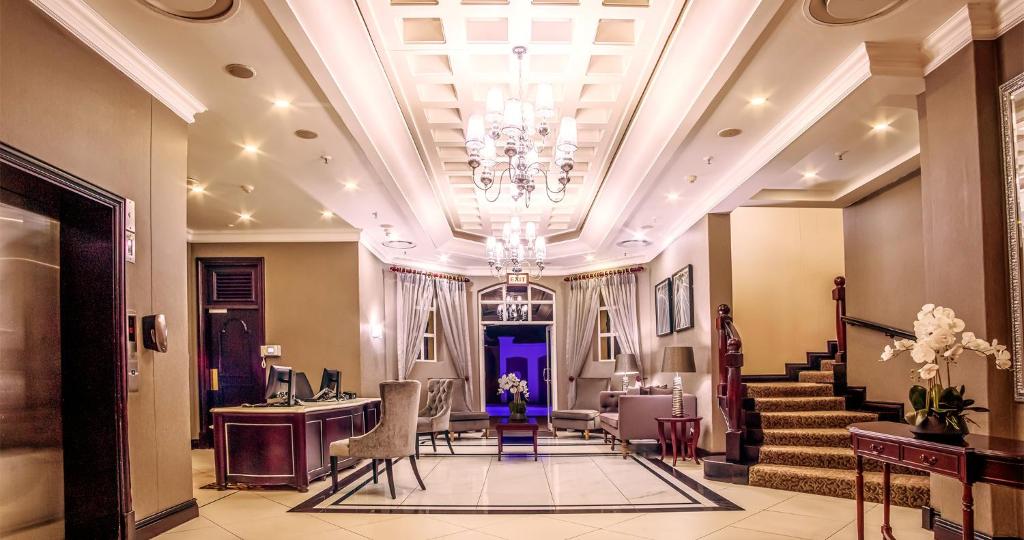 a lobby with a staircase and a chandelier at The Ridge Hotel in Witbank