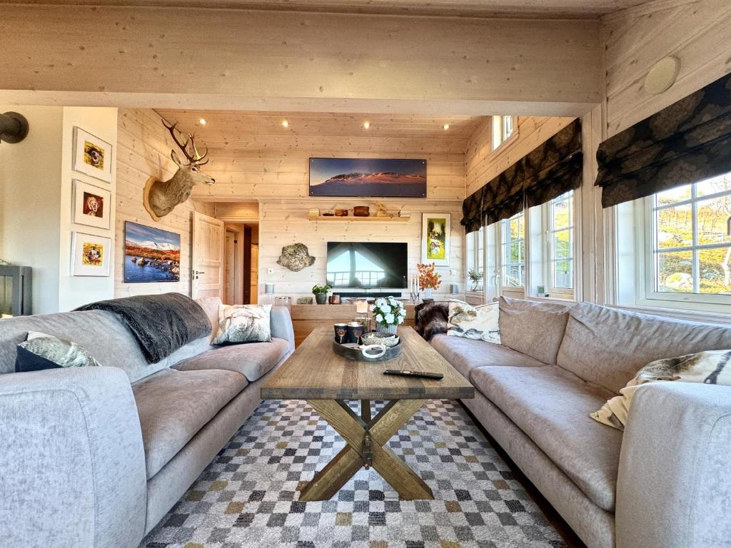 a living room with a couch and a table at Cozy Ski-In Ski-Out Apartment on Geilo, Stunning Views! in Geilo