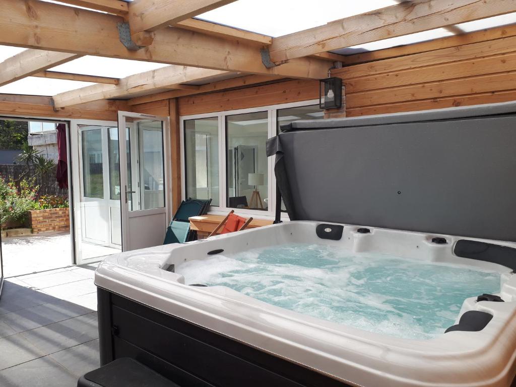 d'une grande baignoire installée au-dessus d'une terrasse. dans l'établissement La Foliotte - Appartement Jacuzzi, à Jullouville