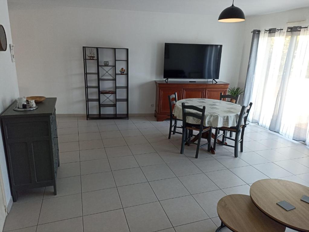 un salon avec une table et une télévision dans l'établissement Angenehmes Haus, à Perros-Guirec