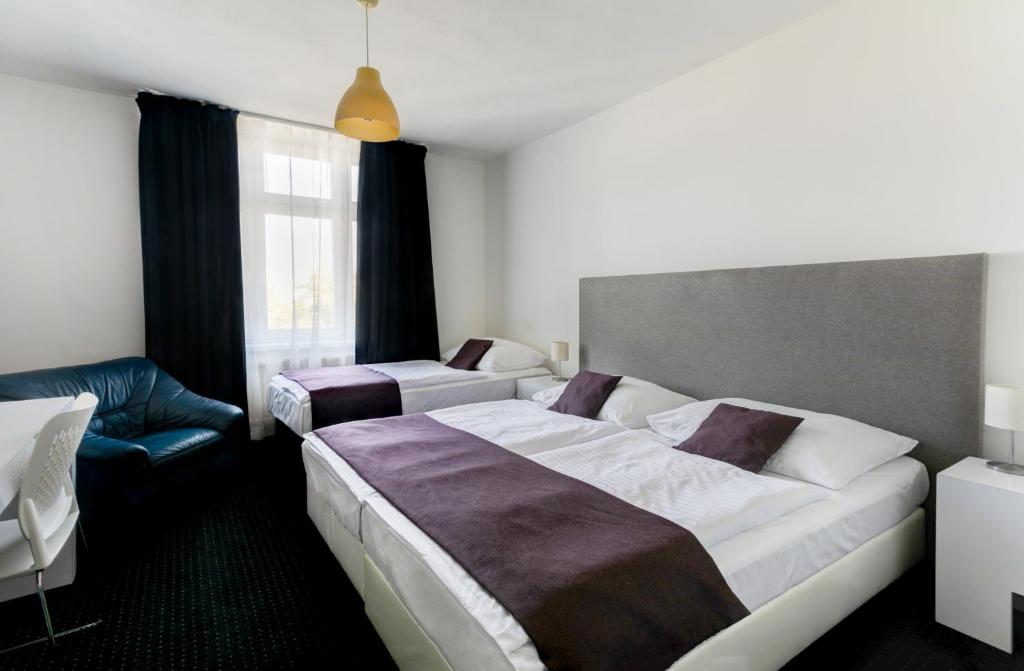 Pokój hotelowy z dużym łóżkiem i krzesłem w obiekcie My Hotel Apollon w Pradze