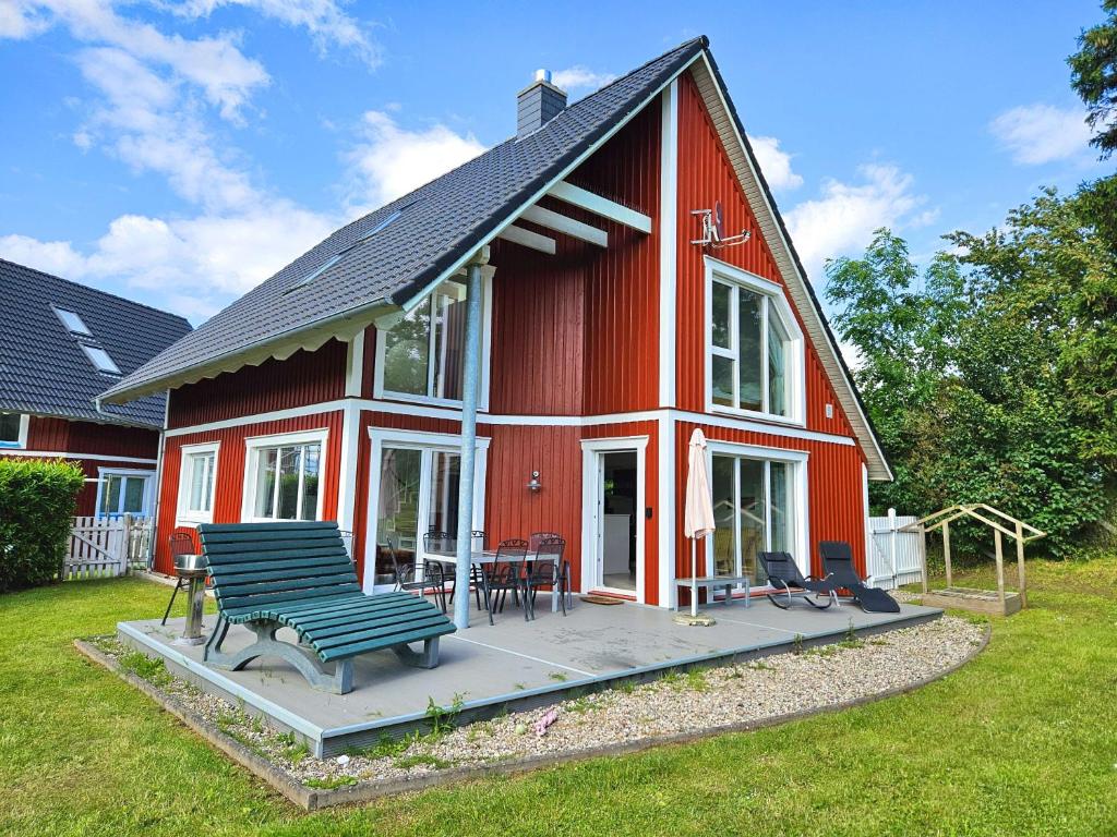 a red house with a bench in front of it at Sechendorf Ferienhaus Solviken Sechendorf in Blekendorf