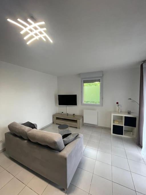 un salon avec un canapé et une télévision dans l'établissement Cosy 3 Pièces Toulouse Jean Chaubet - 4-5 Pers, à Toulouse