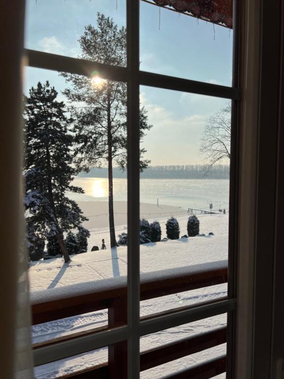 okno z widokiem na plażę w śniegu w obiekcie Resort Maják w mieście Horní Soběšovice