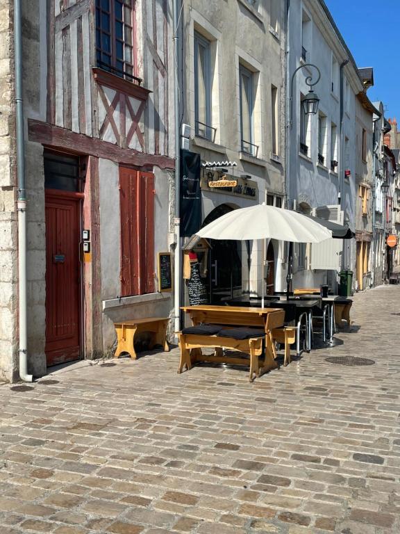 a table with an umbrella on a city street at Glycine in Orléans