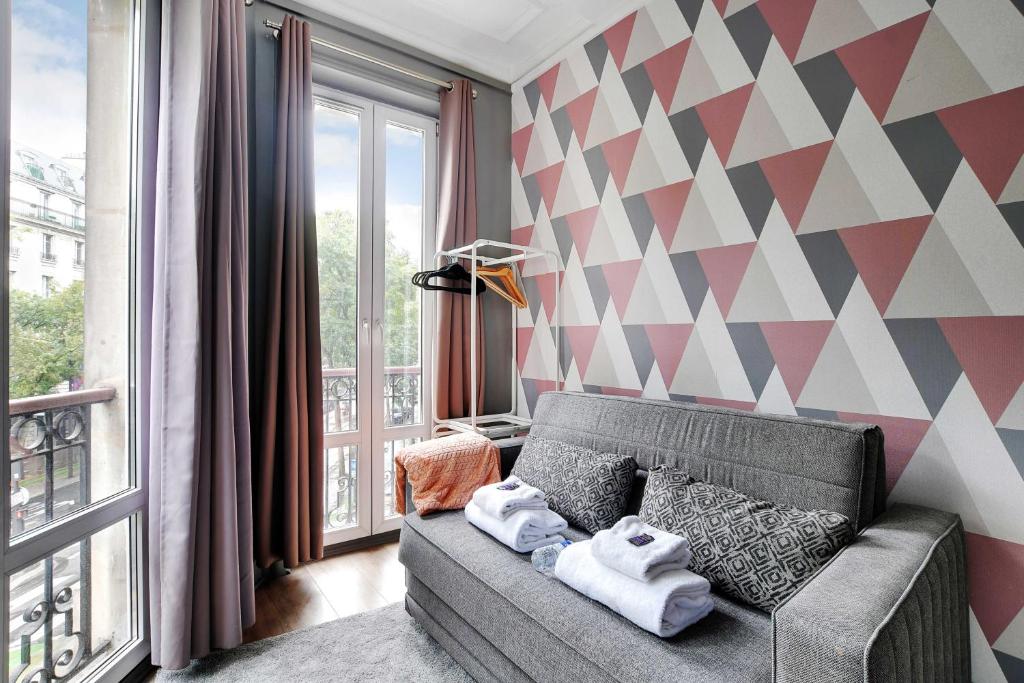 - un salon avec un canapé et un mur géométrique dans l'établissement Peaceful studio - 2P - Near the Canal Saint-Martin, à Paris
