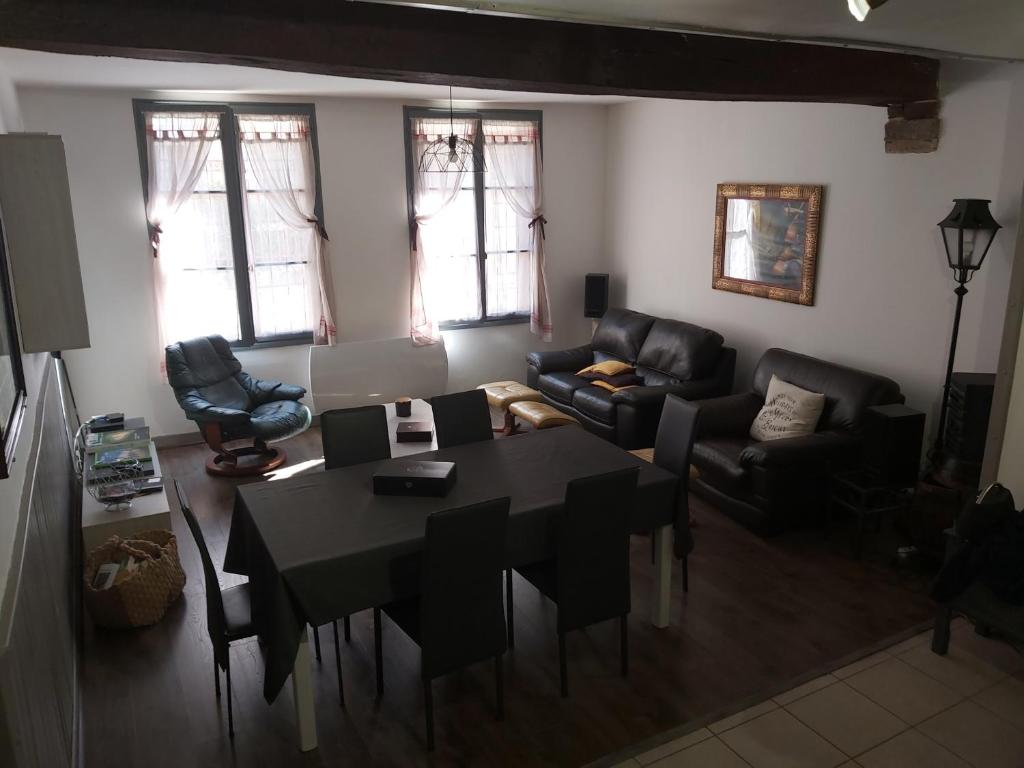 un salon avec une table et des chaises noires dans l'établissement Grande maison de ville au centre Saint Aignan, à Saint-Aignan