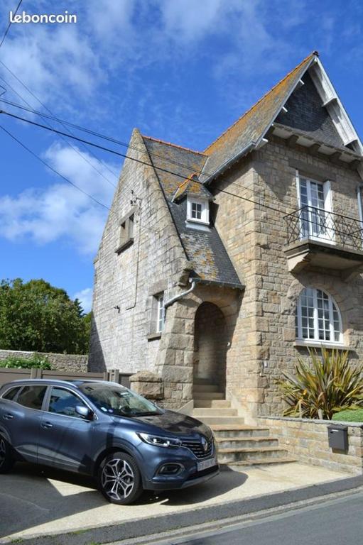 une voiture garée devant un bâtiment en pierre dans l'établissement Maison typiquement Malouine, à Saint-Malo
