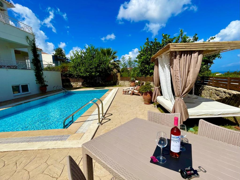 a patio with a table and a swimming pool at Villa Arkadi in Tragaki