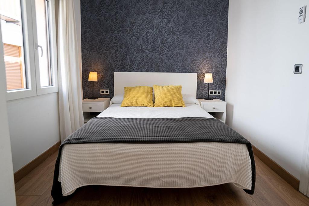 sypialnia z łóżkiem z 2 żółtymi poduszkami w obiekcie Hotel El Cid w mieście Morella