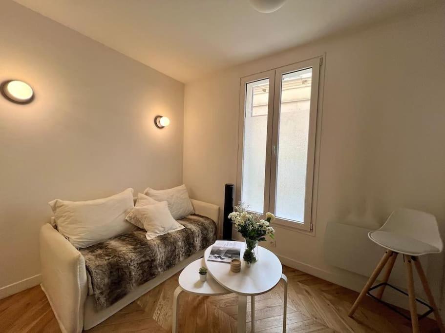 un salon avec un canapé et une fenêtre dans l'établissement Le Cosy Parisien - Au cœur du 13ème - 14MB, à Paris