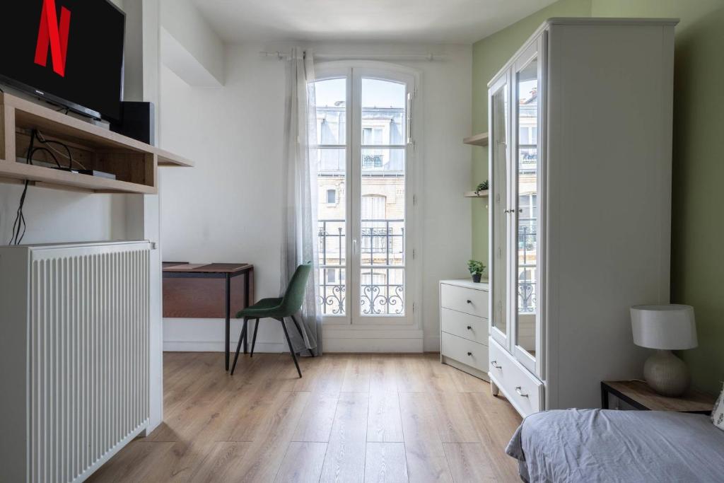 une chambre avec un lit, un bureau et une fenêtre dans l'établissement Cocon aux portes de Paris | By Airnest, à Clichy