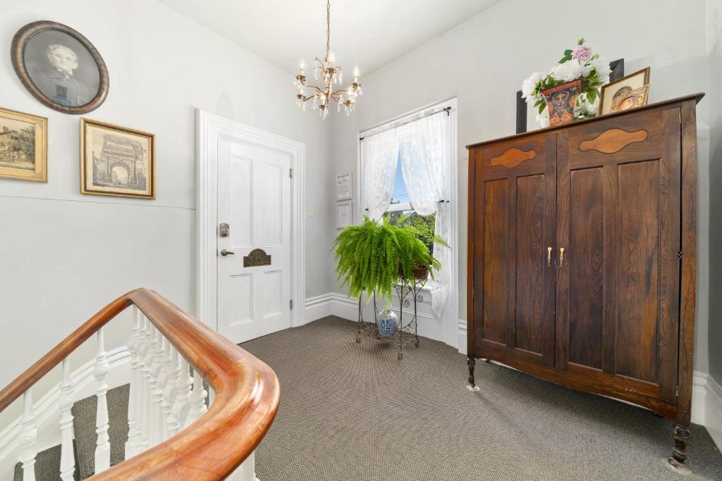 a room with a staircase and a wooden cabinet at The 1885 Suites in Picton
