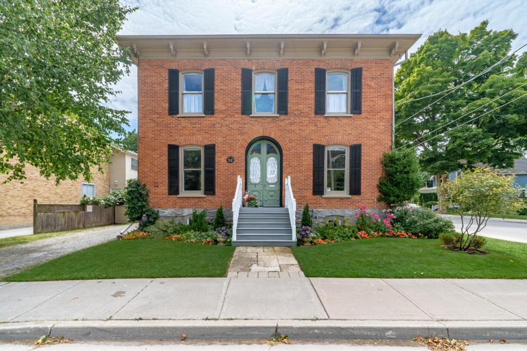 a brick house with a green door at The 1885 Suites in Picton