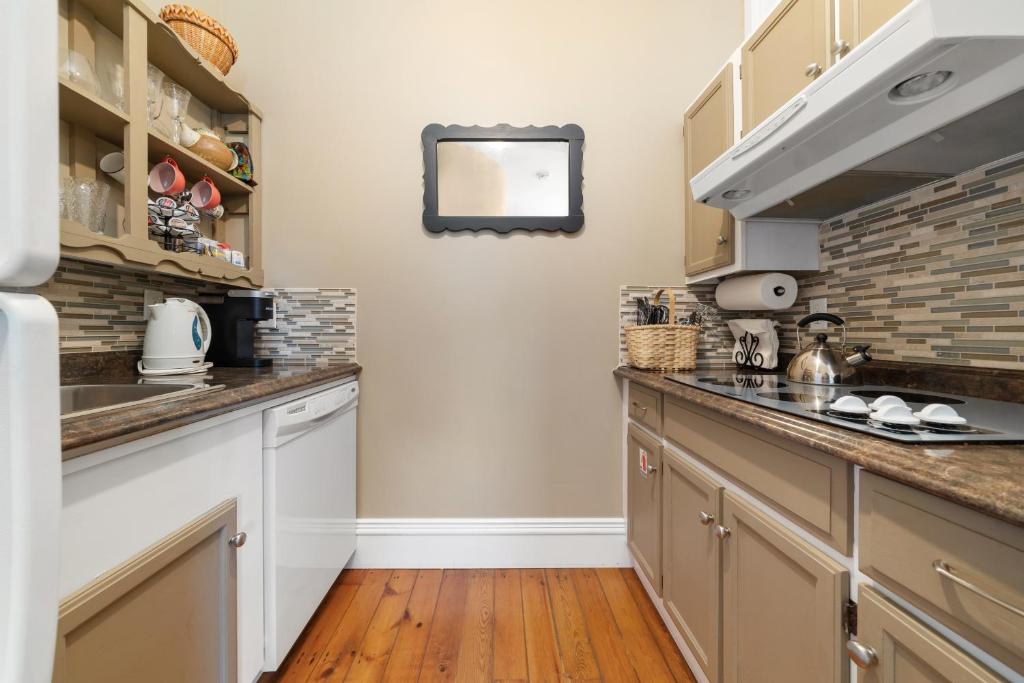 a kitchen with white cabinets and a counter top at The 1885 Suites in Picton