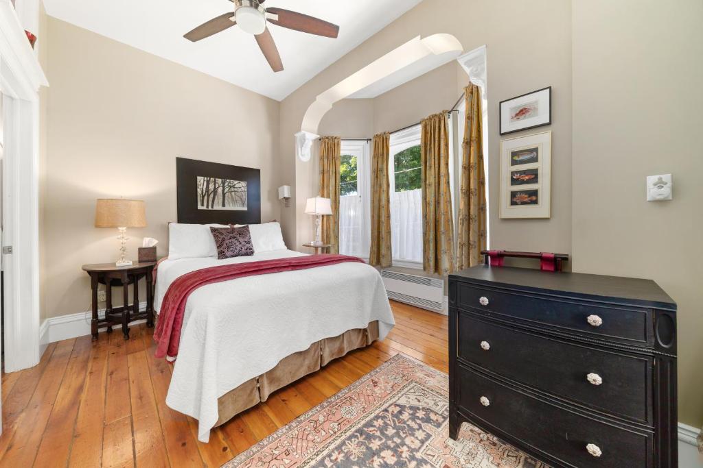 a bedroom with a bed and a dresser and a window at The 1885 Suites in Picton