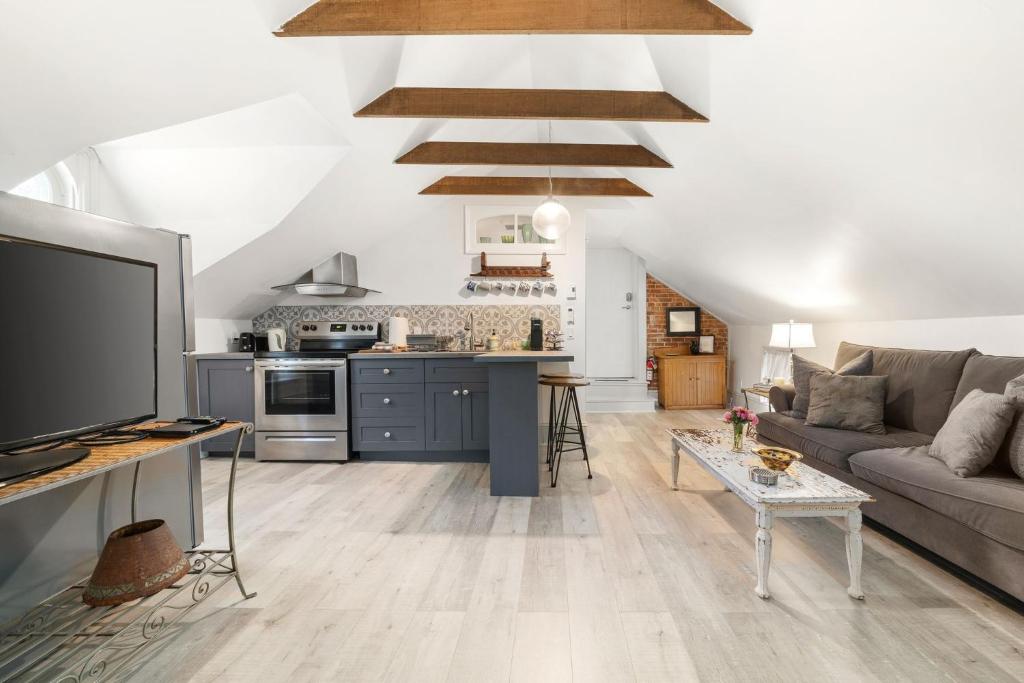 a living room with a couch and a kitchen at The 1885 Suites in Picton