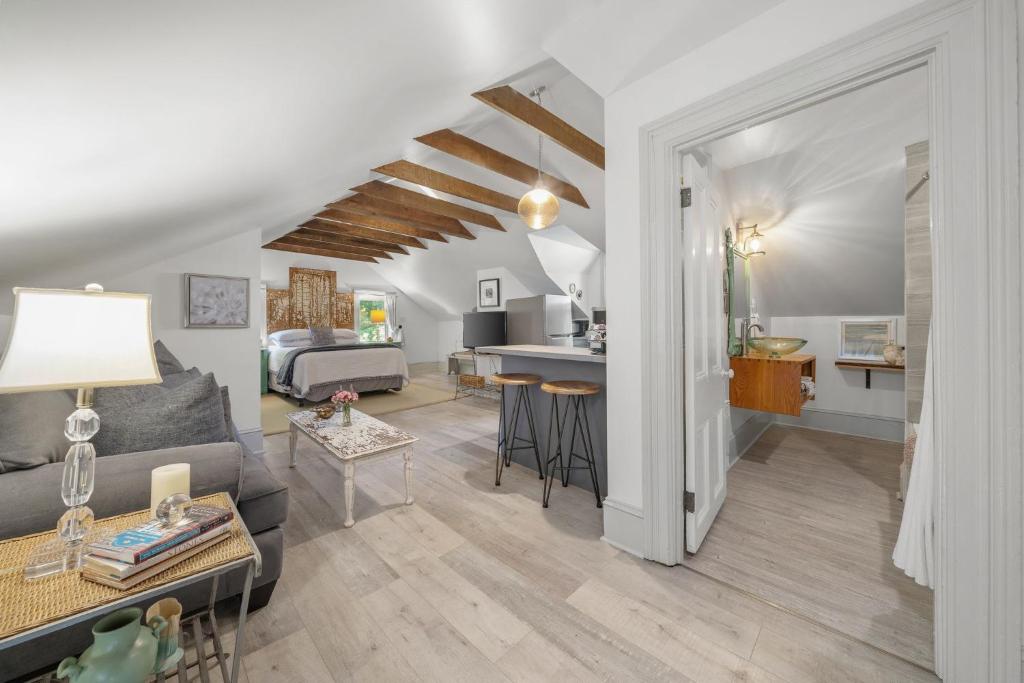 a living room with a couch and a table and a kitchen at The 1885 Suites in Picton