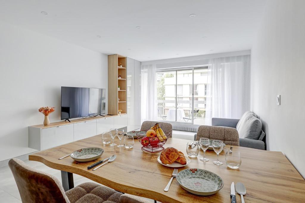 une salle à manger avec une table avec des assiettes et des verres à vin dans l'établissement Suite au Cœur de Paris, Architecturale et Élégante, à Paris