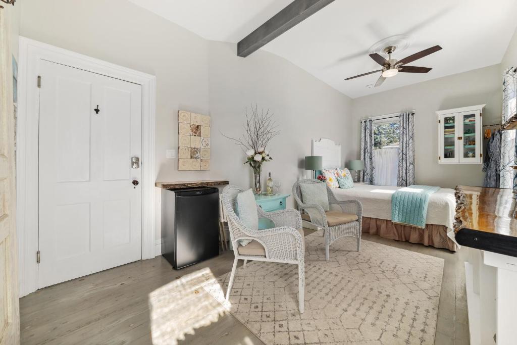 a bedroom with a bed with two chairs and a table at The 1885 Suites in Picton