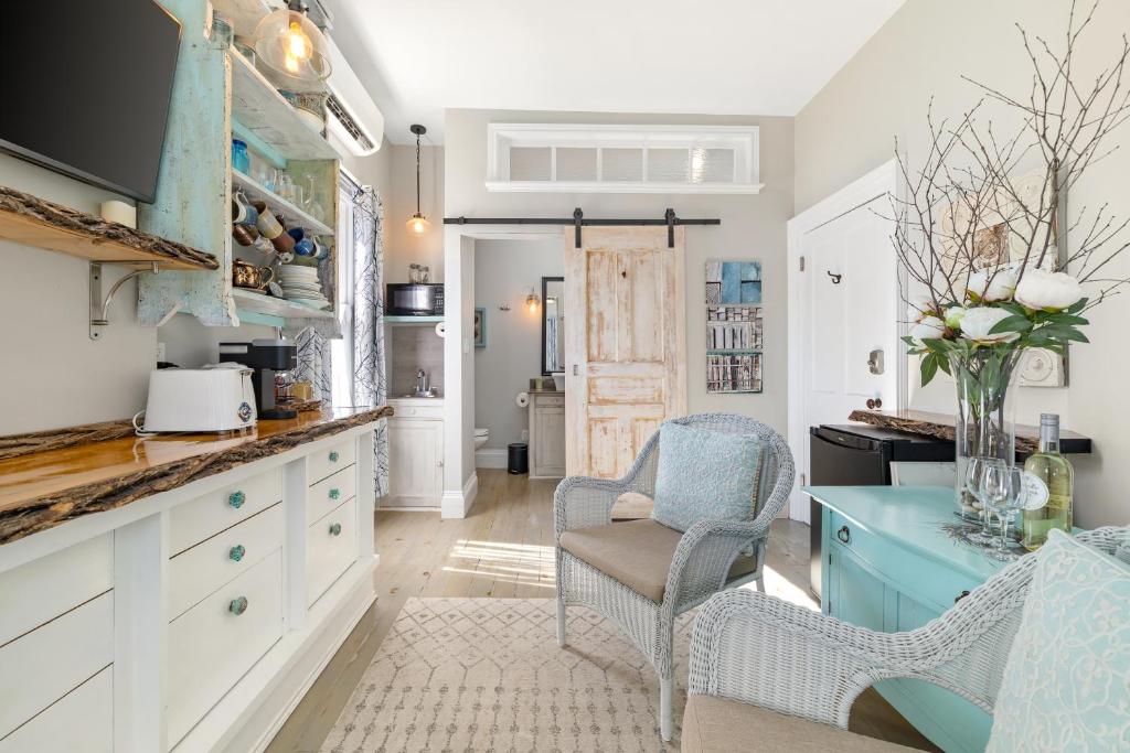 a kitchen with blue and white cabinets and chairs at The 1885 Suites in Picton