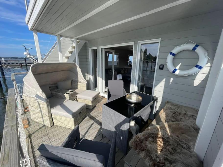 a porch with chairs and a table on a boat at Hausboot Sophie in Stralsund in Stralsund