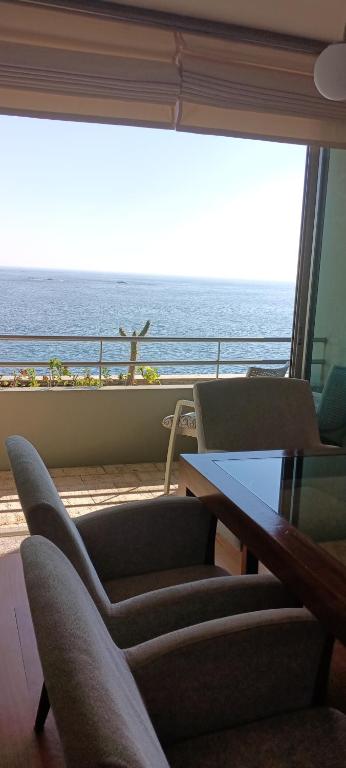 a room with a table and chairs and a view of the ocean at Matosinhos -Seas Apartment- Cabo das Marés in Matosinhos