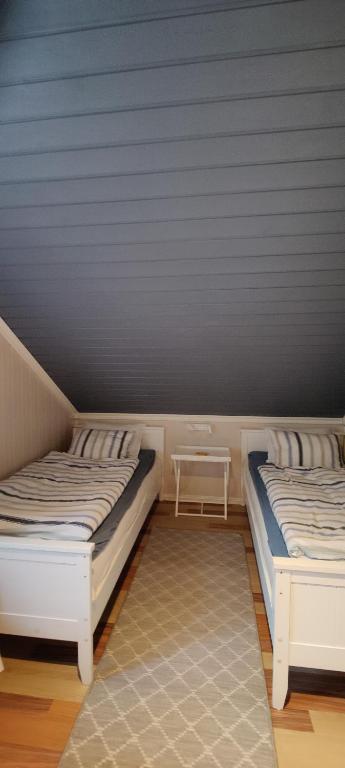 サルプスボルグにあるØya husrom 2のベッド2台とテーブルがある部屋