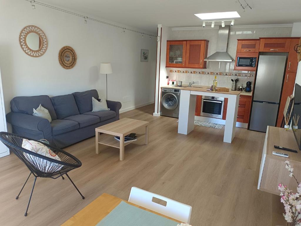 a living room with a blue couch and a kitchen at Casa Valentina in Tías