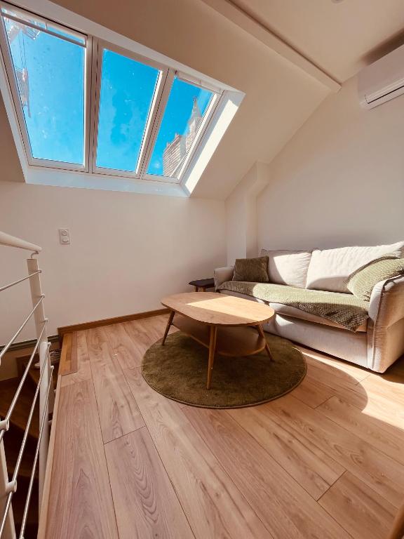 un salon avec un canapé et une table dans l'établissement appartement terrasse Roof Top climatisé, à Gaillac