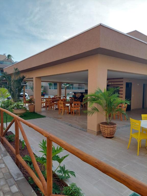 a building with a deck with tables and chairs at Flecheiras in Trairi
