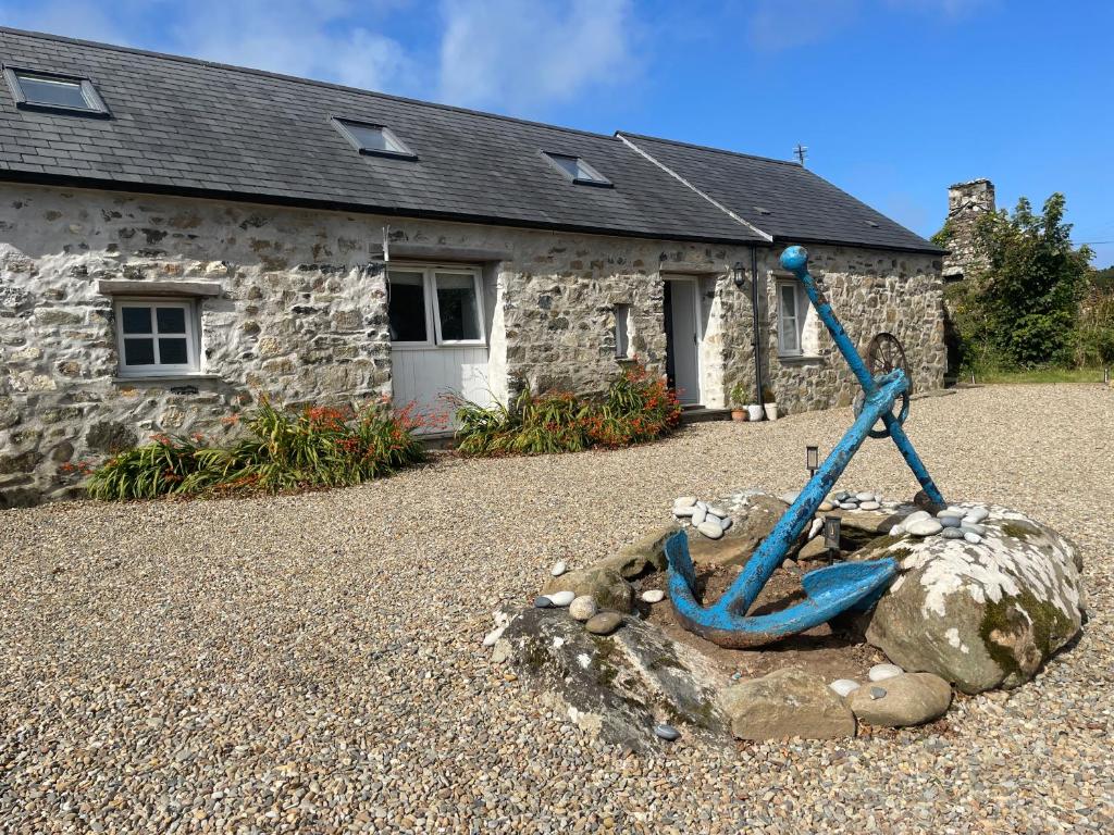 una estatua frente a una casa de piedra en Trefechan Wen Barn, en Llanwnda